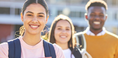 Three young students posing and smiling at the camera